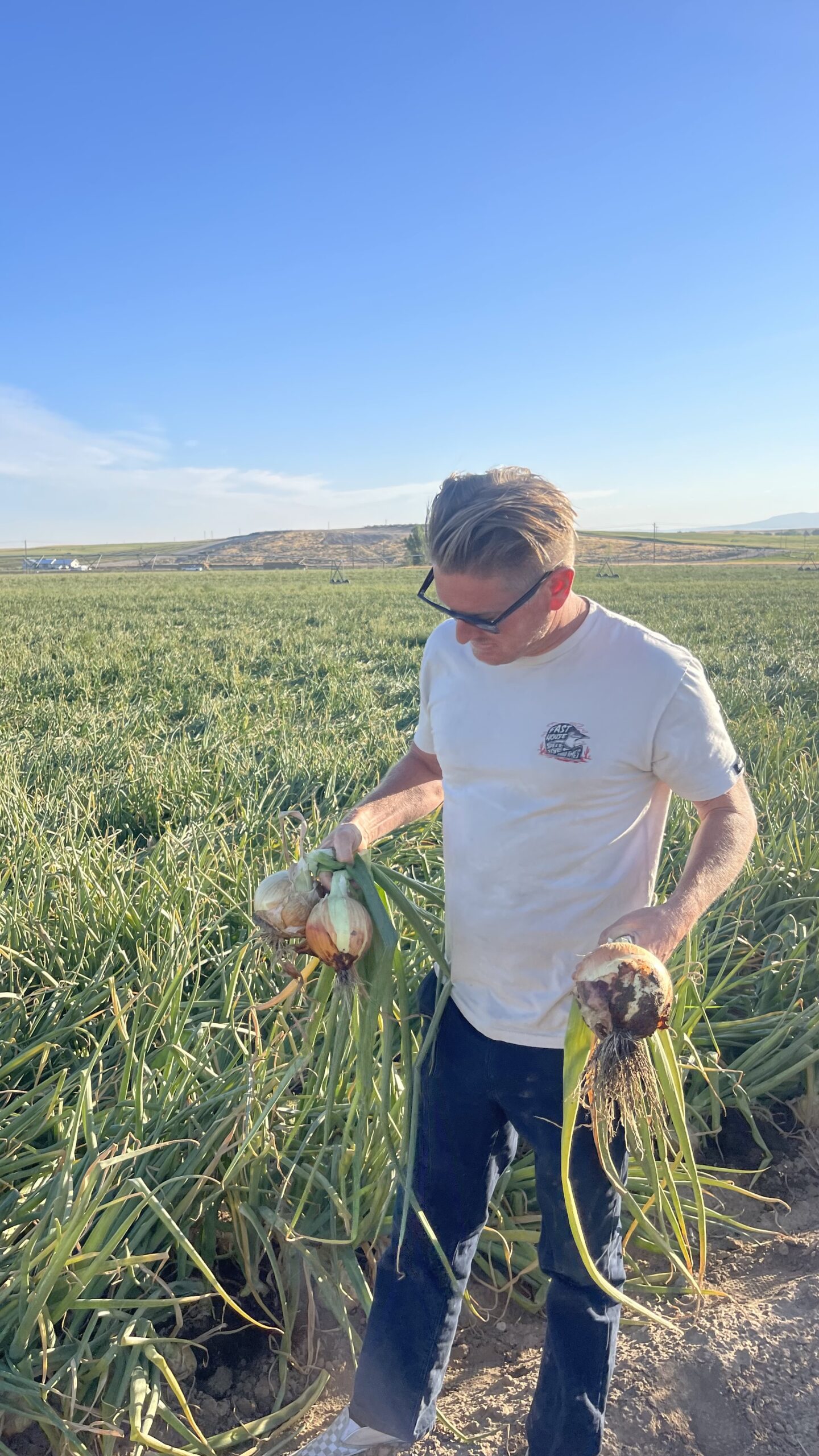 Russell Frisby with yellow onions grown using KhushFul, Caldwell ID